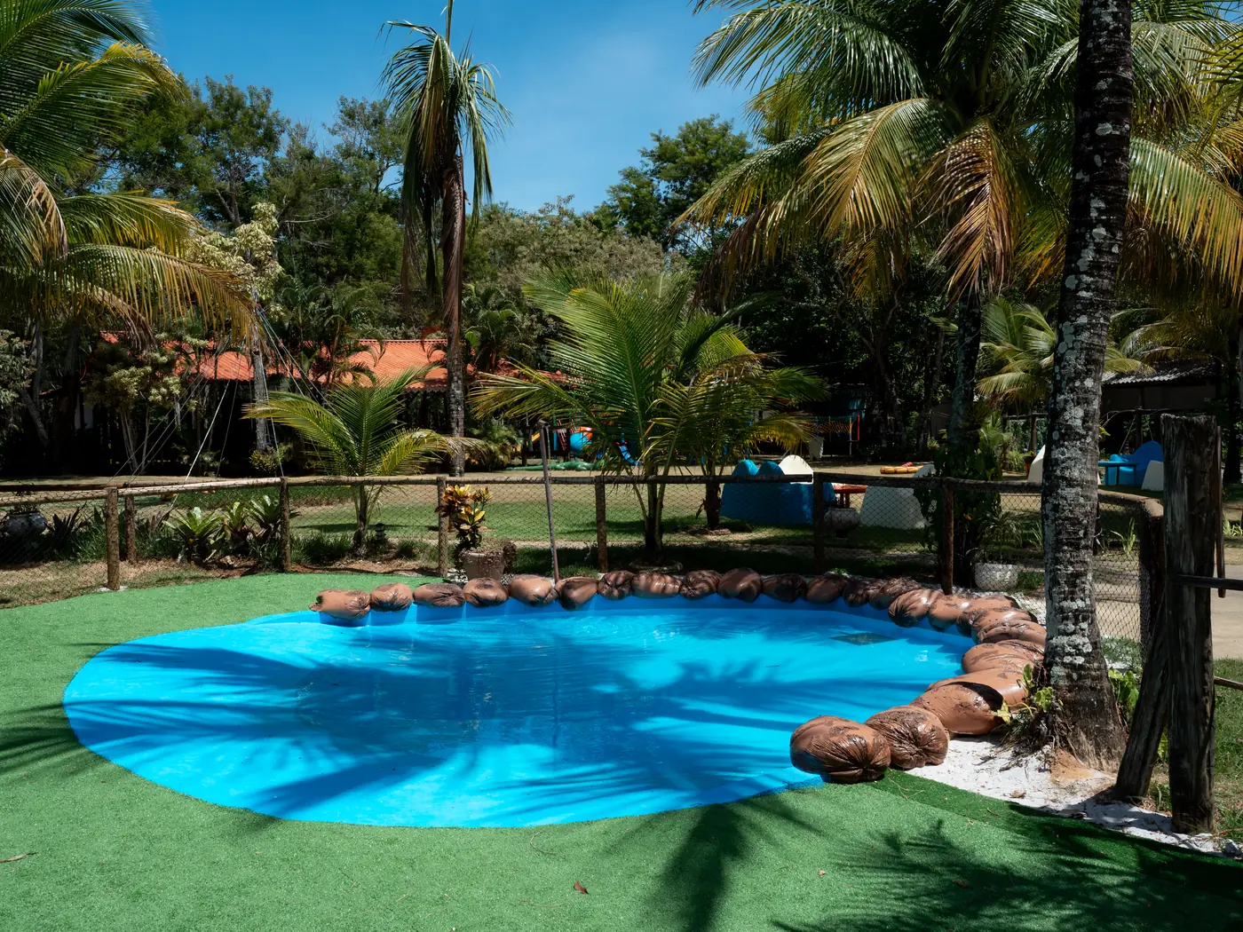 Área verde do Acquamarine Park Hotel com coqueiros e piscina infantil