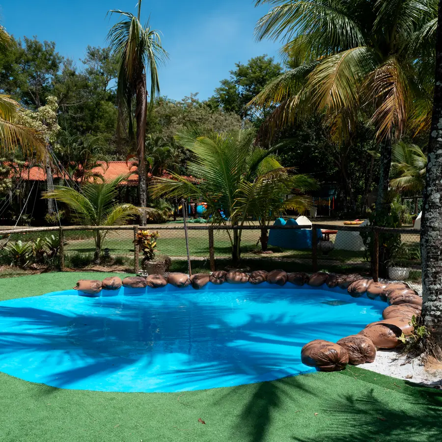 Área verde do Acquamarine Park Hotel com coqueiros e piscina infantil