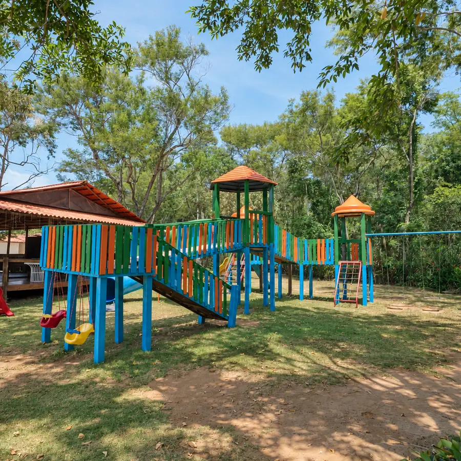 Playground do Acquamarine Park Hotel com escorregador e brinquedos no gramado