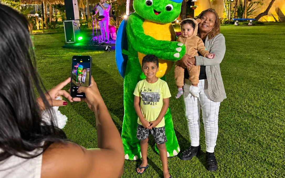 Família fotografando o mascote do hotel na programação noturna